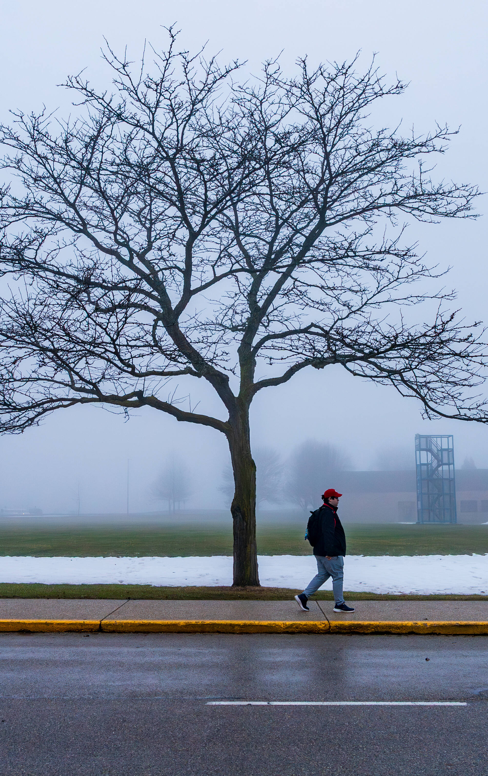 Group social studies and secondary education major Dylan Sawyer walks in the fog near the Haas Center for the Performing Arts Practice Field on February 27.